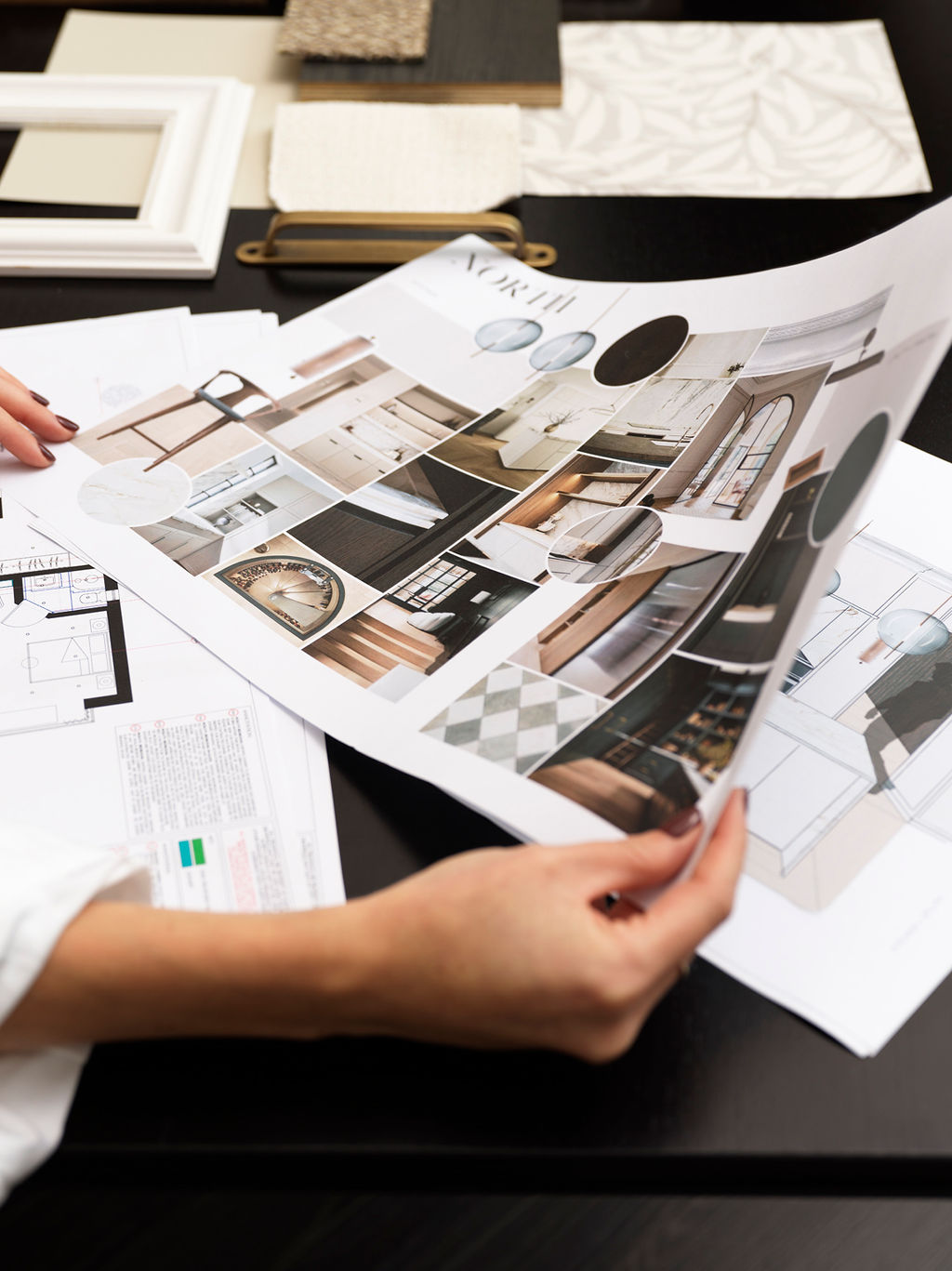 A North design pack being reviewed over floor plans and material samples